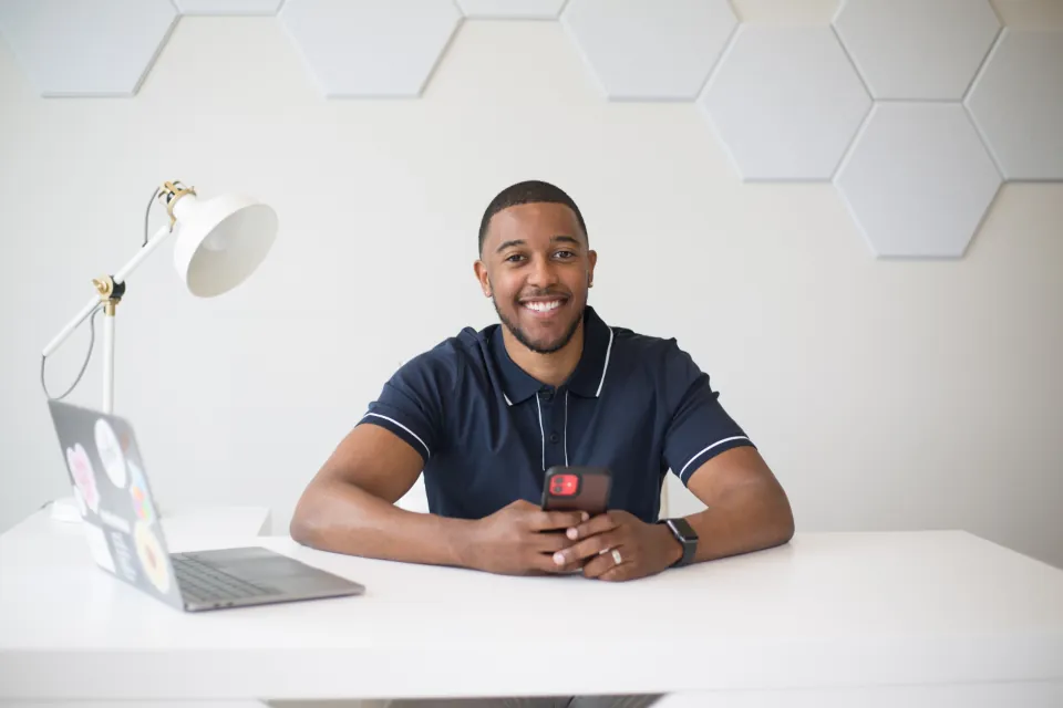 Professionnel souriant à son bureau devant un ordinateur portable