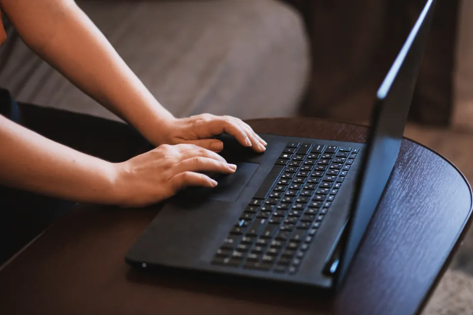 Mains sur le clavier d’un ordinateur portable